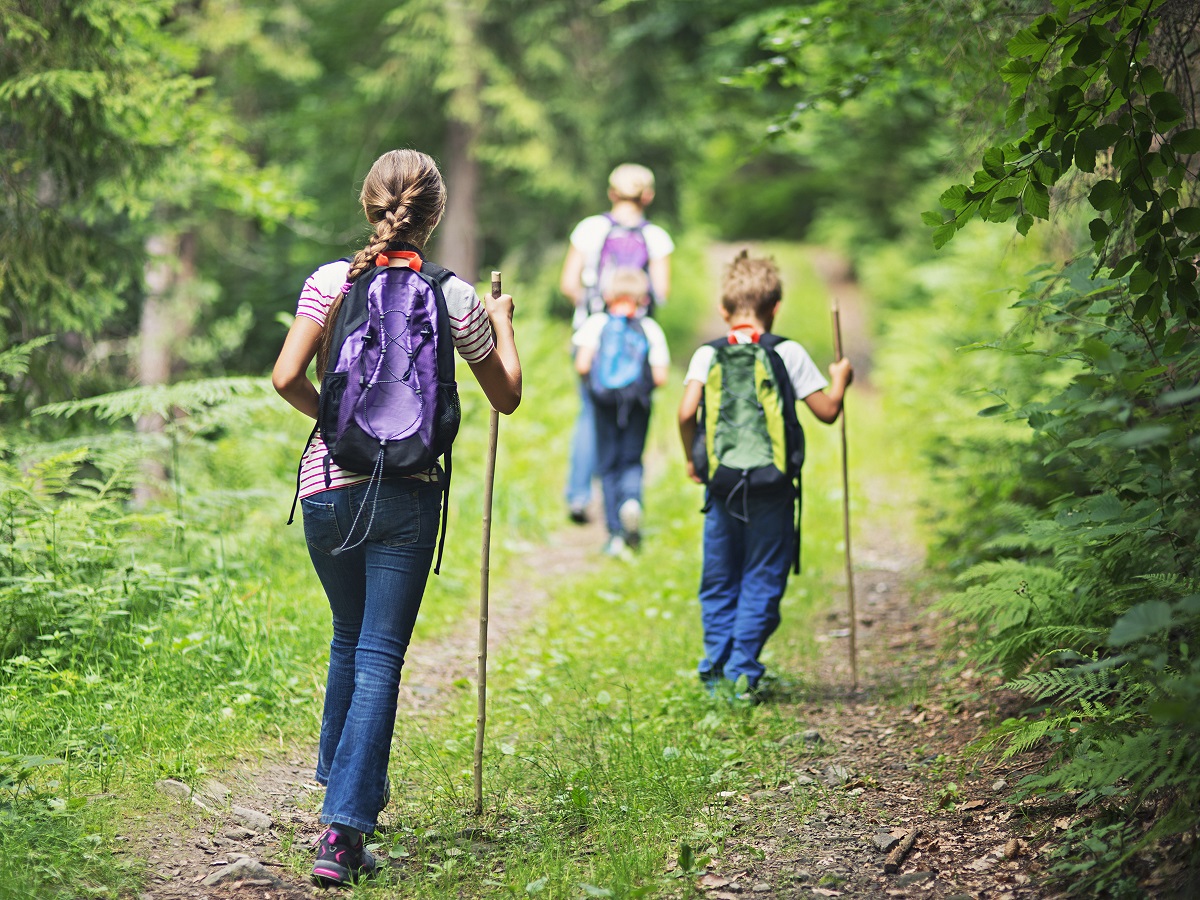 Mother and kids hiking along a pathway enjoying nature on an Adventure Travel experience.