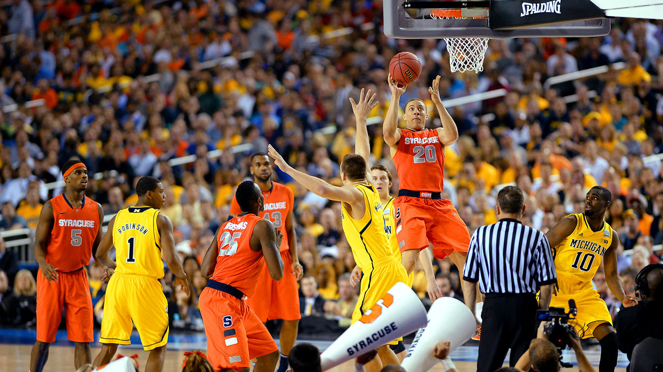Michigan and Syracuse college basketball players face off in a NCAA game.
