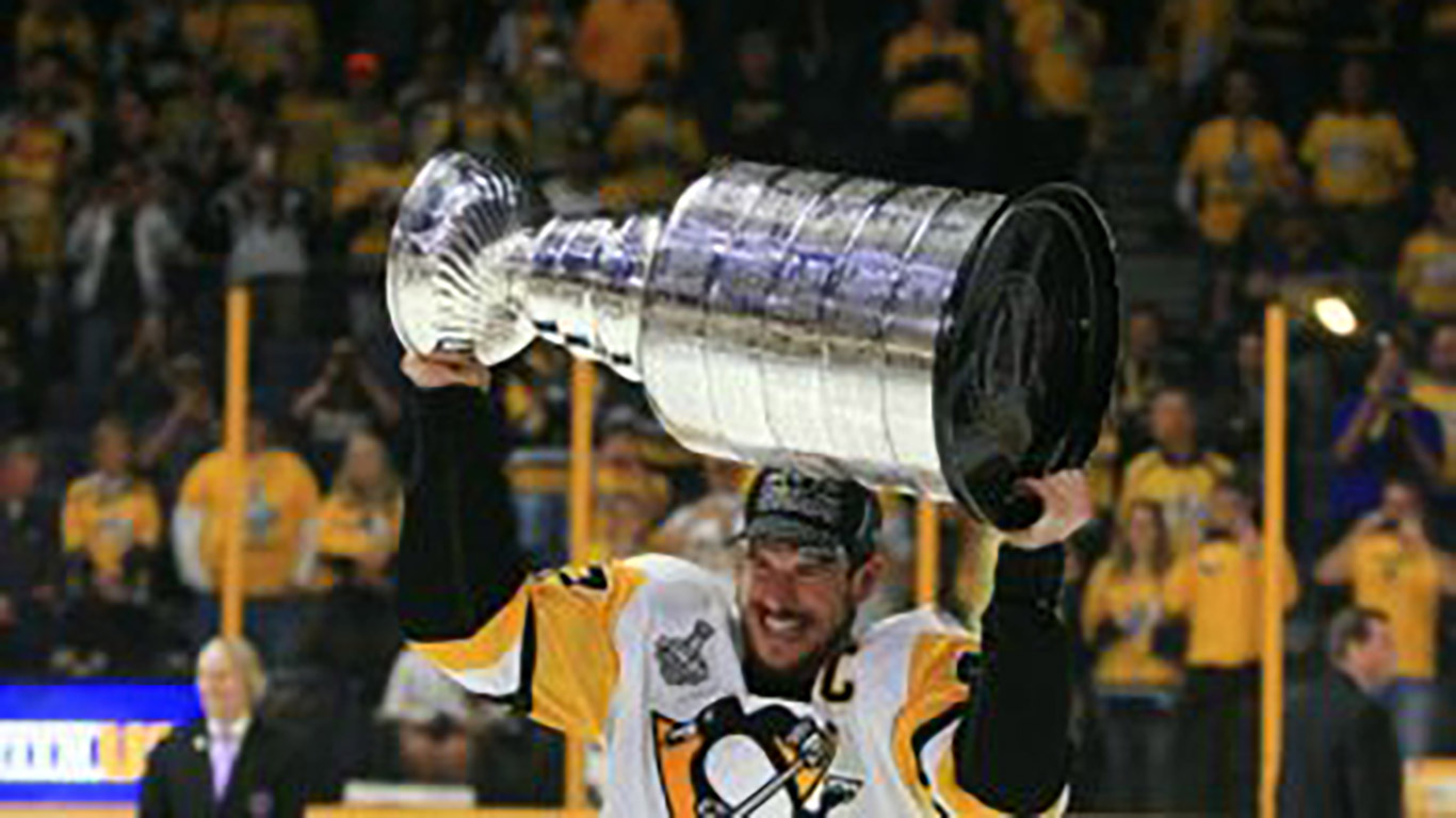 Pittsburgh Penguin hockey player, Sidney Crosby hoisting the Stanley Cup. Join the action.